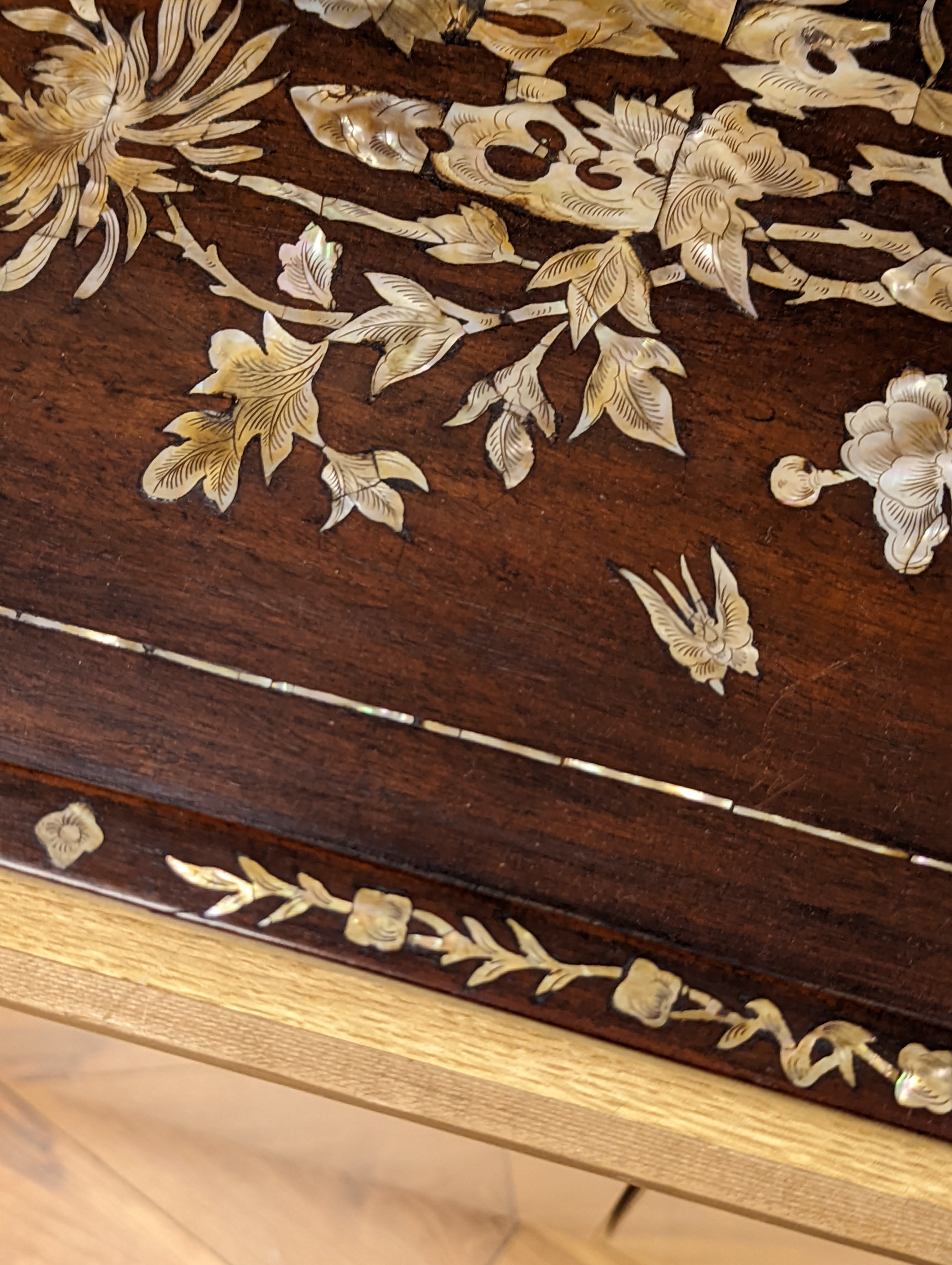 Two Chinese mother of pearl inlaid hongmu trays, the rectangular example with birds and insects amid flowers and the smaller oval example with a pavilion in a landscape within floral sprays 55x34cm